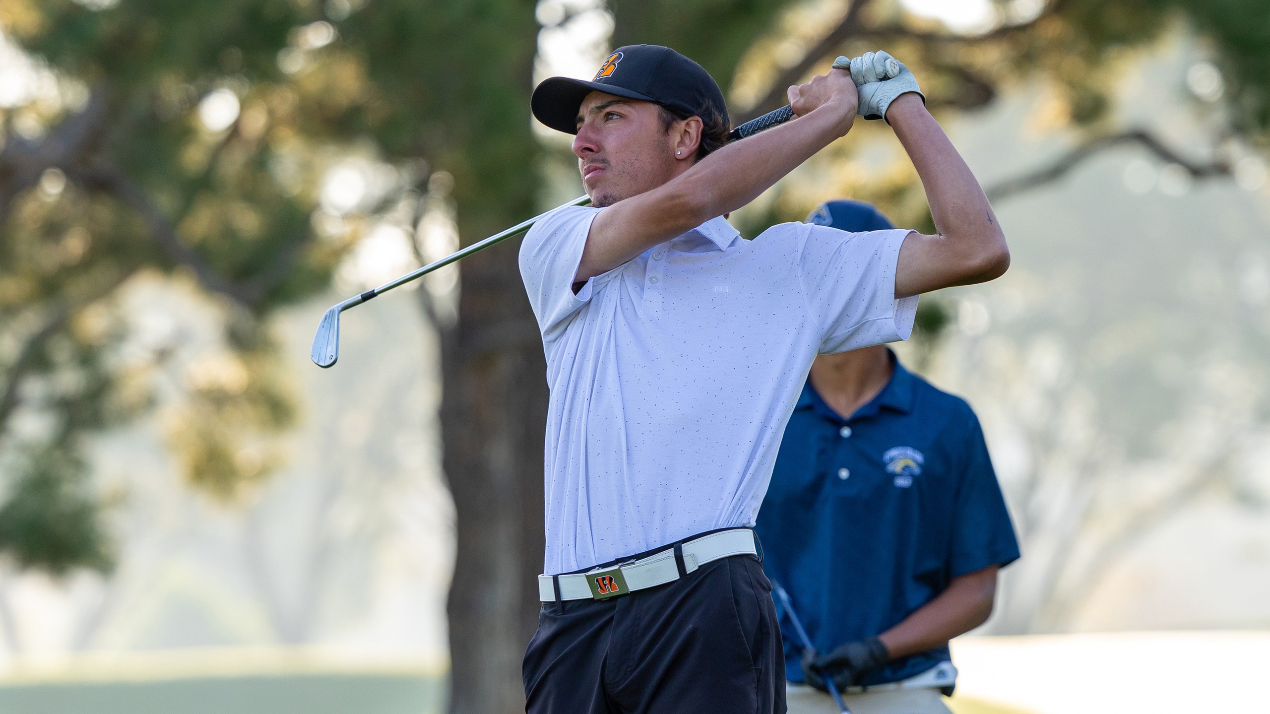 Elijah Gonzales looks on after swinging a golf club