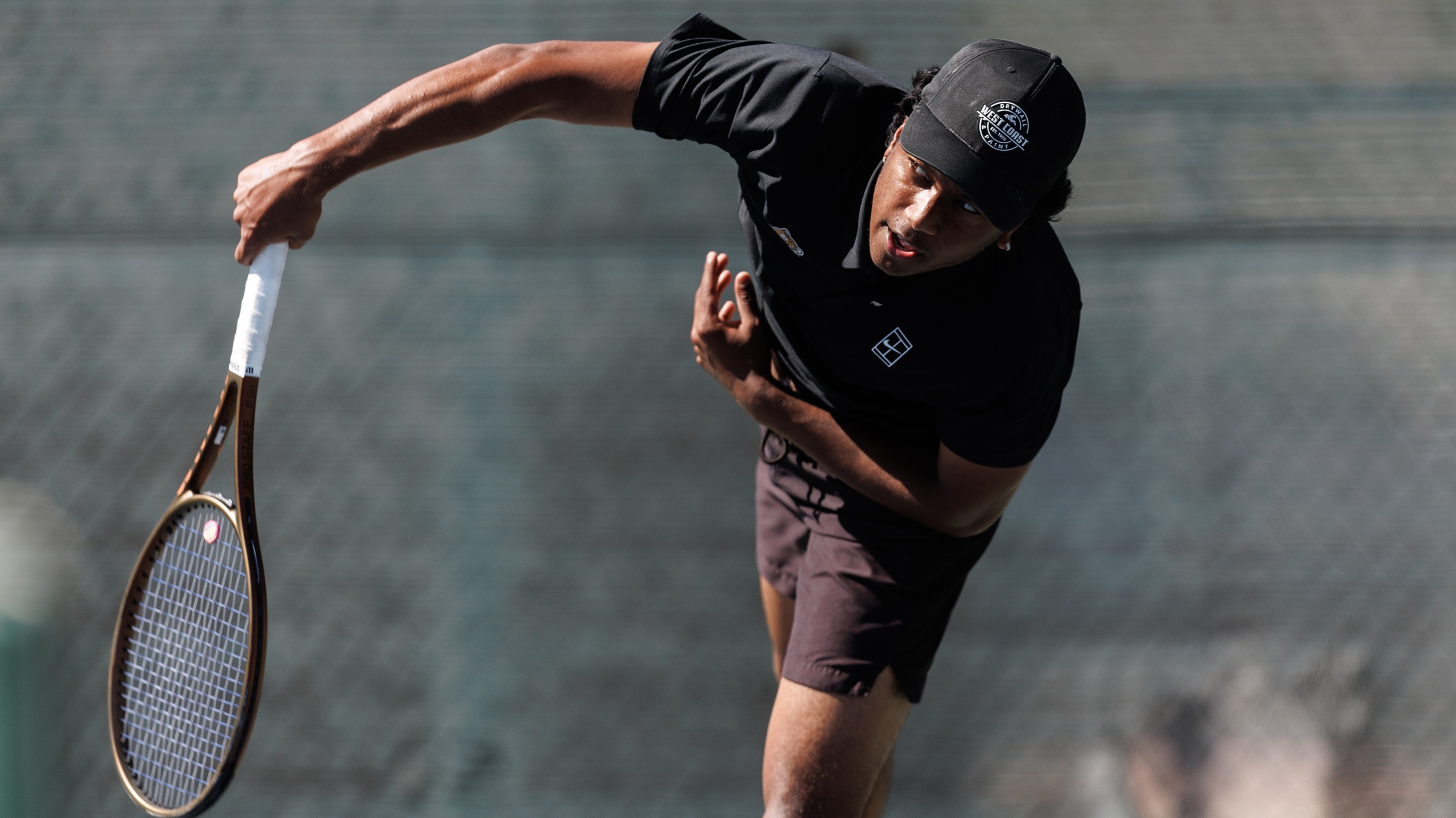 Men's tennis player hits the ball